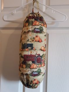 an oven mitt hanging from a hook on a door hanger with pumpkins and trucks