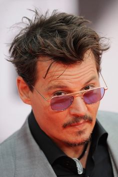 a man with glasses and a mustache wearing a suit