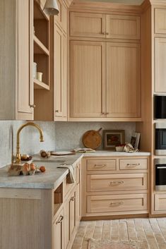 a kitchen with wooden cabinets and marble counter tops