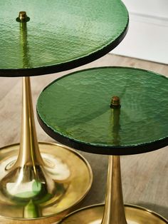 two green glass tables sitting on top of each other