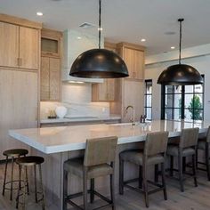 a large kitchen with an island and bar stools