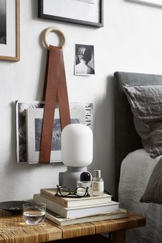 an image of a bedroom setting with books and eyeglasses on the table next to the bed