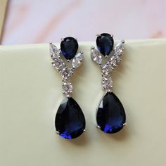 Small vintage style  zircon  earrings Prom jewelry Colour: rhodium (silver tone)/clear/blue Measurements: approx 3.2 cm x 10 mm  including studs (small and delicate).  Materials:  rhodium components, zircon crystals. Stud earrings. Great for wedding or other celebration. SAME STYLE with clear crystals: https://www.etsy.com/uk/listing/622909721/bridal-jewelry-bridal-earrings-crystal?ref=shop_home_active_89 MORE SAME STYLE: https://www.etsy.com/uk/shop/BridalArtDeco?ref=listing-shop-header-item-count&section_id=23918122 Please note some images have been enlarged to allow for details to be shown. Read the descriptions for details on actual size of each item. In all my shop listings I have made every effort to ensure that the images match the item as closely as possible! However, colours do va Crystal Drop Earrings Wedding, Earrings Zirconia, Blue Bridal Earrings, Drop Earrings Wedding, Earrings Prom, Earrings Art Deco, Crystal Bridal Earrings, Wedding Earrings Drop, Prom Earrings