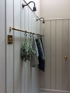 an instagram page with clothes hanging on hooks and plants in the corner next to them