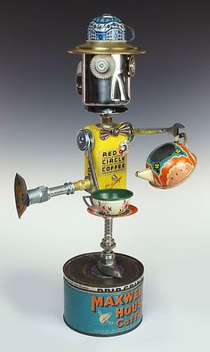 a metal robot holding a cup on top of a tin can