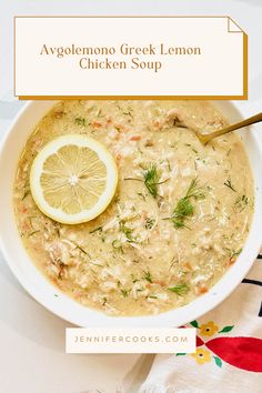 a white bowl filled with chicken soup next to a slice of lemon on top of a table