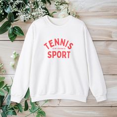 Looking for the ideal gift for the tennis enthusiast in your life? Look no further! Our crewneck is a thoughtful and practical present that will be cherished by anyone who loves to swing a racket. The simple yet bold design proudly declares "Tennis is my Favorite Sport," showcasing your unwavering devotion to the game. Whether you're a seasoned player or just a fan of the sport, this crewneck is sure to become a staple in your wardrobe. Ideal for any situation, a unisex heavy blend crewneck swea White Sportswear Tops For Tennis, Cotton Tennis Sweatshirt With Relaxed Fit, Sporty Sweatshirt With Screen Print For Sports, Relaxed Fit Crew Neck Top For Tennis, Cotton Tennis Tops With Letter Print, Casual White Sweatshirt For Tennis, White Relaxed Fit Top For Tennis, Casual White Tennis Sweatshirt, White Relaxed Fit Tennis Top