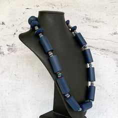 This unique blue wood necklace was hand beaded using a stylish mix of ethnic beads - navy blue wooden cylinders, distressed navy wood rondelles, small wooden beige beads, and beautiful 8mm round blue ceramic beads.  The necklace measures approximately 33.5 inches in length and is securely fastened with a sterling silver toggle clasp.  Perfect for any gender and fits in so well with today's boho looks!  Lightweight and comfortable to wear.  Length can be adjusted if needed - just ask! Wood repres Unique Blue Wooden Beads, Blue Wooden Beads, Unique Blue Wooden Beaded Necklaces, Artisan Blue Wooden Beads, Blue Wooden Beads For Jewelry Making, Traditional Blue Wooden Beaded Necklaces, Boho Looks, Navy Blue Earrings, Mens Beaded Necklaces