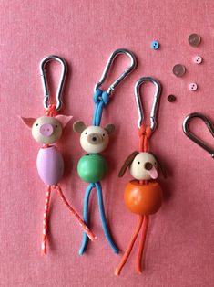 three keychains with animals on them sitting next to some scissors and other items