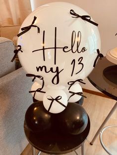 a balloon with the words hello my 13 written on it sitting on a chair in front of a table