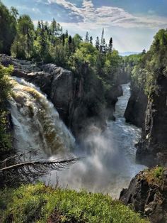 a large waterfall surrounded by lush green trees