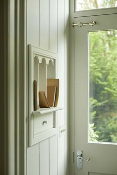 a white door with some cutting boards on it and a window in the back ground