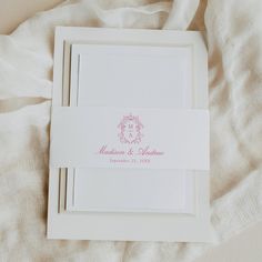 the wedding stationery is laid out on top of the bed sheets and linens