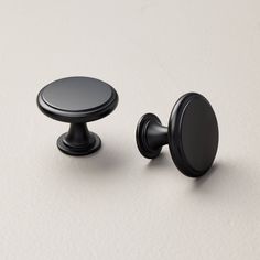 two black knobs on a white surface