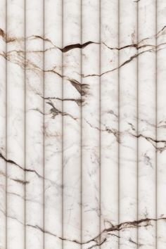 a white marble wall with vertical lines in the center and diagonals on each side