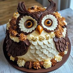 an owl cake is decorated with chocolate and white icing on a wooden table top