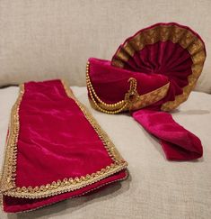 a red and gold purse sitting on top of a white couch