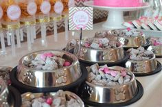 there are many desserts on the table with pink and white frosted treats in bowls