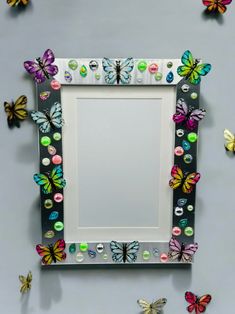 a mirror that has some butterflies on the wall next to it and is decorated with buttons