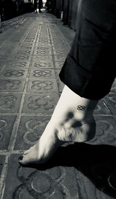 a person's foot with the word love tattooed on their left ankle, in black and white