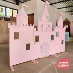 a pink castle made out of cardboard sitting on the floor