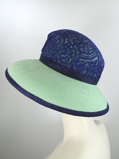 You'll look great in this pretty green and navy wool felt hat! It can easily transition from Winter to early Spring and is perfect for any dressy occasion. Imagine walking into church with this beauty! The flattering asymmetrical wide brim hat had a slight turned down brim with a cut out on the right side. It's topped with a gorgeous, extra wide ombre navy and green five loop bow that has a gorgeous Czech glass button in the center. This hat that will be the envy of everyone who sees it! The top Fitted Hat With Short Brim And Lining, Wide Brim Felt Cloche Hat, Green Fedora For Kentucky Derby, Green Adjustable Felt Hat For Kentucky Derby, Fur Felt Brimmed Cloche Hat, Kentucky Derby Fur Felt Cloche Hat With Flat Brim, Green Sun Hat With Flat Brim, Green Short Brim Felt Hat For Kentucky Derby, Formal Brimmed Felt Hat For Spring