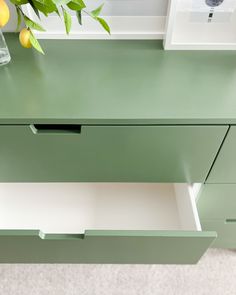 a green dresser with two drawers and some lemons