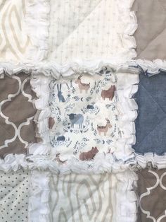 *Gorgeous handmade quilt with three cozy layers. FREE SHIPPING TO US AND CANADA, ready to ship! SAL$ priced! This quilt features Dear Stella "Into the Wild" animal print with co-ordinating patterned fabrics in taupe, denim blue and off white. Each square is quilted with a traditional "X" and seams are handclipped to create a cozy fringe.  Outside edge is double stitched for durability.  SPECS Top layer: 100% cotton quality fabrics  Middle and backing layer: cozy white flannel Measures approx. 32.5" x 42.5" (crib size) *Rag quilts make a unique keepsake/heirloom gift for baby, and this is the perfect size from birth to toddlerhood. *Please see photos for details regarding colours and layout, I do my best to provide accurate descriptions and photographs, however I do not have control over ho Nursery Gender Neutral, Quilt Baby Blanket, Patterned Fabrics, Jean Quilt, Baby Rag Quilts, Girl Cribs, Quilt Care, Heirloom Gifts, White Flannel