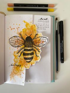 an open notebook with a drawing of a bee on it