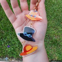 a hand holding three different shaped key chains