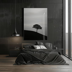 a black and white photo of a bed in a room with wooden floors, a painting hanging on the wall