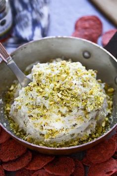 a silver bowl filled with food on top of a table