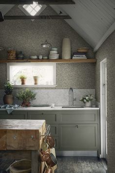 a kitchen with green cabinets and wooden flooring is shown in an attic style home