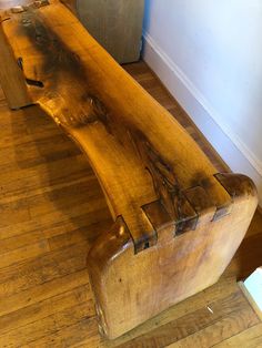 a wooden bench sitting on top of a hard wood floor