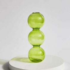 a green vase sitting on top of a white plate