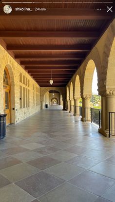 an empty walkway with arches and pillars on both sides is seen in this image from the phone