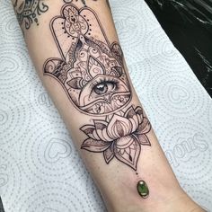 a woman's arm with a hamsah tattoo on it and an eye in the middle