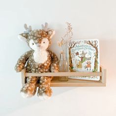 a stuffed animal sitting on top of a wooden shelf