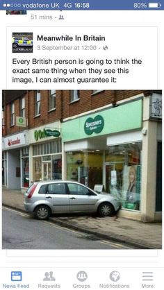 a car parked in front of a store on the side of a street next to a building