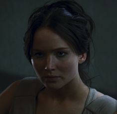 a close up of a person wearing a tank top and looking at the camera with a serious look on her face