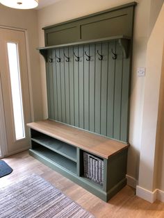 a green bench sitting in the middle of a room next to a rug and door