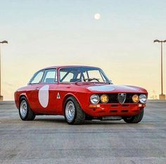 an old red car with white circles on it's front and side bumpers