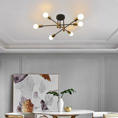 an elegant dining room with marble tables and gold chairs, artwork on the wall above