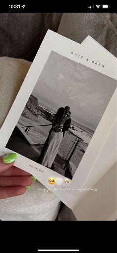 a person holding up a book with an image on the front and back cover in their hands