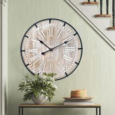 a clock that is on the wall next to a table with flowers and books in it