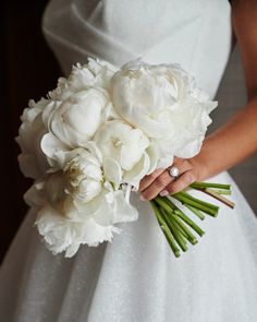 a bride holding a bouquet of white flowers