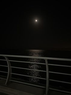 the moon is shining over the water at night on the deck of a cruise ship