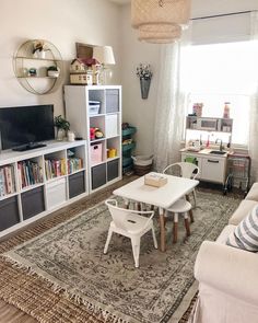 a living room filled with furniture and a flat screen tv on top of a wooden table