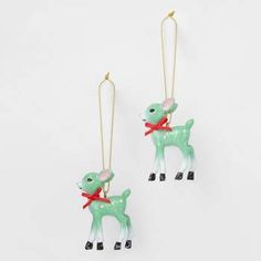 two green and white deer ornaments hanging from gold earwires with red ribbon around their necks