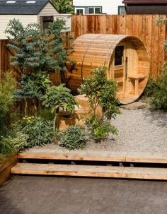 a wooden barrel like structure in the middle of a garden with steps leading up to it